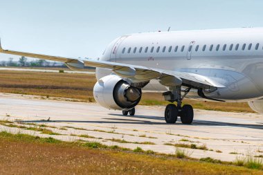 Büyük yolcu uçağı havaalanında pist boyunca sürüyor.