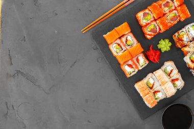 Gri arka planda servis edilen suşi ruloları.