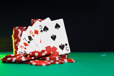 Poker masasında kırmızı oyun fişleri ve kartları
