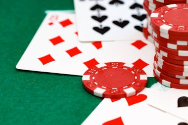 Poker masasında kırmızı oyun fişleri ve kartları