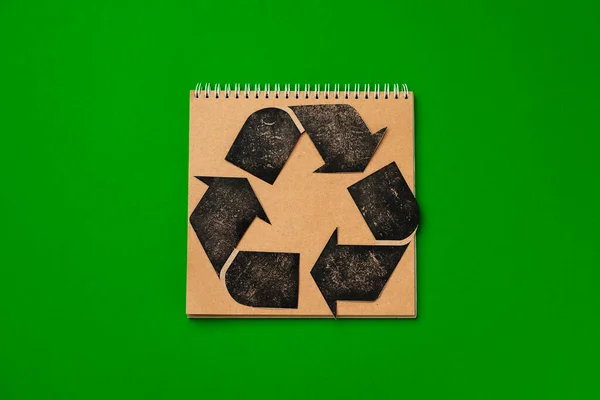 Paper recycling concept on green background top view