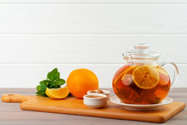 Siyah çay ve narenciye parçalı cam çaydanlık.