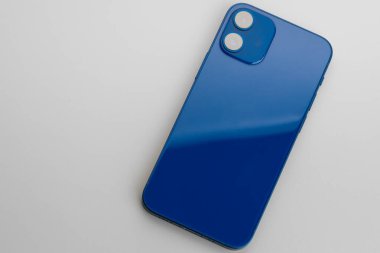 Gri arka planda çift lensli kameralı mavi modern akıllı telefon.