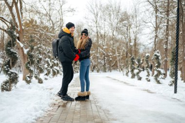 Genç ve mutlu bir çift kış parkında yürüyüş yapıyor.