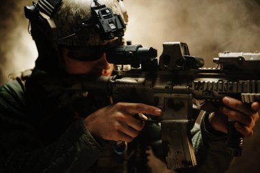 Özel kuvvetler askerleri sisli havada tüfeğini doğrultuyor.