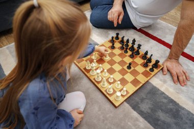 Büyükbaba ve torun evde satranç oynuyorlar.