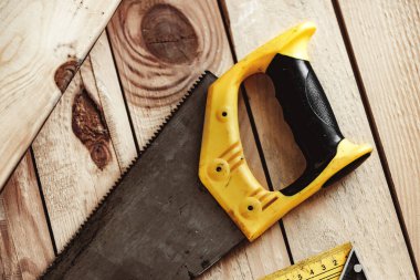 Marangozluk atölyesindeki ahşap bir masada el testeresi.