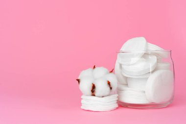 Kağıt arkaplanda bir kavanozda cilt bakımı için pamuk diskler