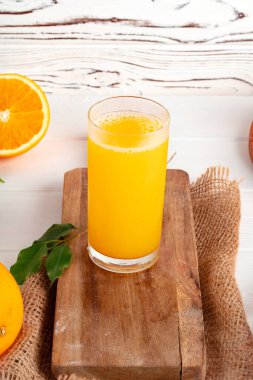 Tahta masadaki portakal suyu bardağını kapat.