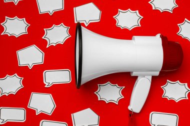 Kırmızı zemin üzerinde konuşma balonu olan elektronik megafon.