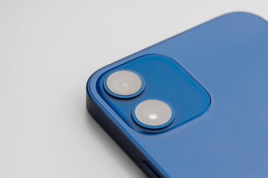 Gri arka planda çift lensli kameralı mavi modern akıllı telefon.