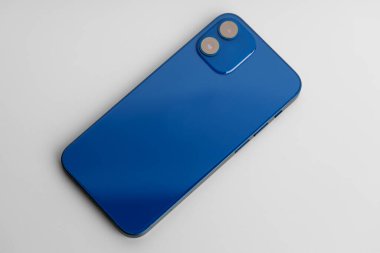 Gri arka planda çift lensli kameralı mavi modern akıllı telefon.