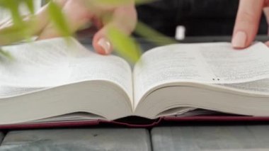 Bir kitabın sayfalarını çeviren kadın ellerini kapat.