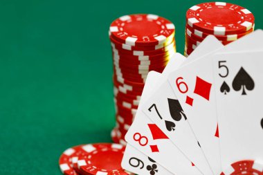 Poker masasında kırmızı oyun fişleri ve kartları