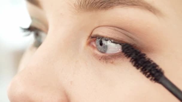 Close up of young female applying mascara on her eyelashes — Stock Video