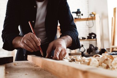 Marangoz tahta üzerinde kalem izleri yapar.