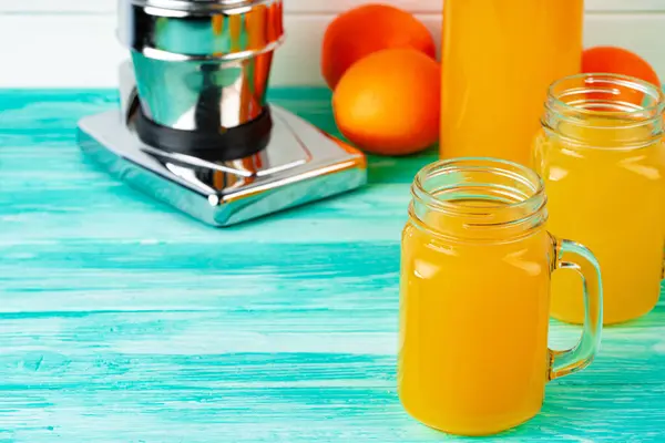 Glass with orange juice on green wooden table — Stock Photo, Image