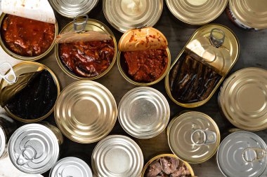 Ahşap zemin üzerinde balık rezervleri olan açık konserve kutularının üst görünümü