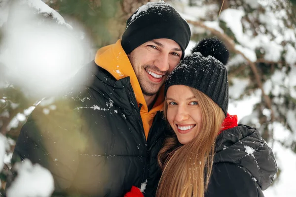 Happy couple hugging and smiling outdoors in snowy park — Stock Photo, Image