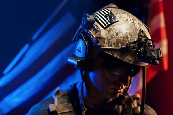 Portrét vojáka speciálních jednotek v brýlích a helmě proti americké národní vlajce — Stock fotografie