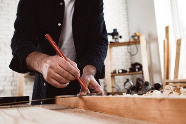 Marangoz tahta üzerinde kalem izleri yapar.