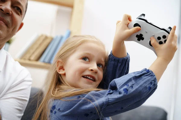 Avô e neta jogando videogames em casa. — Fotografia de Stock