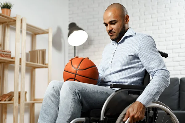 車椅子保持バスケットボールボールの悲しい若い障害者の男 — ストック写真