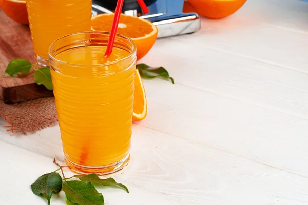 Glass of orange juice with red straw on table — Stock Photo, Image
