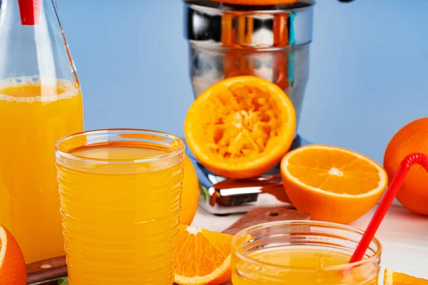 Bottle of orange juice and fresh oranges on table — Stock Photo, Image