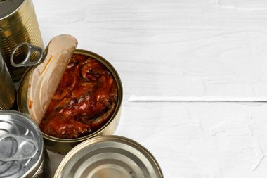 Bir sürü konserve balık ve ahşap masa.