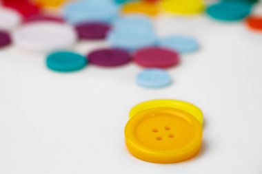 Beyaz arkaplanda çeşitli renkli düğmeler