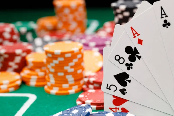 Hrací karty a žetony na zeleném pozadí kasina — Stock fotografie