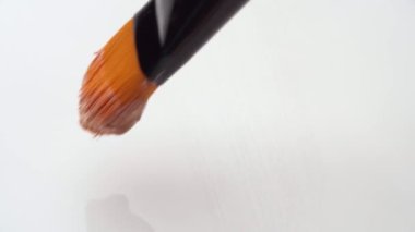 Yüz temeli lekesi, beyaz makyaj paletine yakın fırçayla yapılmış.