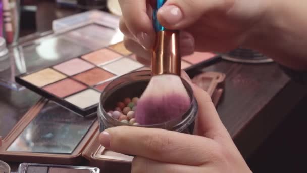 Make-up borstel aanbrengen cosmetische poeder ballen op ijdelheid tafel close-up — Stockvideo