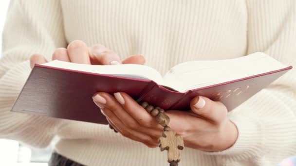 Primer plano de una mujer sosteniendo el libro de la Biblia y cuentas de madera — Vídeo de stock