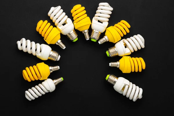 黒の背景に白と黄色の電球 — ストック写真