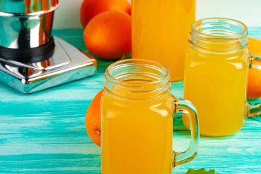 Yeşil ahşap masadaki portakal suyu dolu bardak.