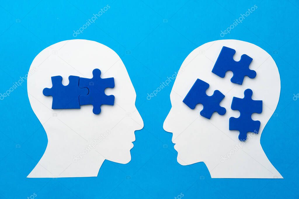 Papercut head with jigsaw puzzle pieces on blue background