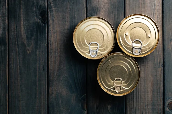 Latas de lata de alimentos fechados no fundo escuro — Fotografia de Stock