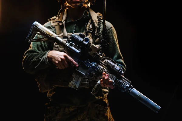 Oigenkännlig specialstyrkor soldat stående med gevär mot svart mörk bakgrund — Stockfoto