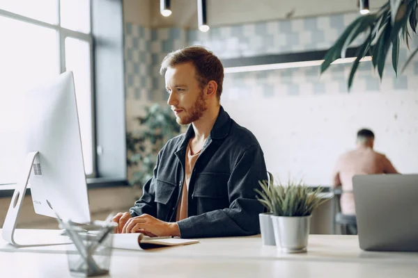 Ung affärsman som arbetar med dator på kontoret — Stockfoto