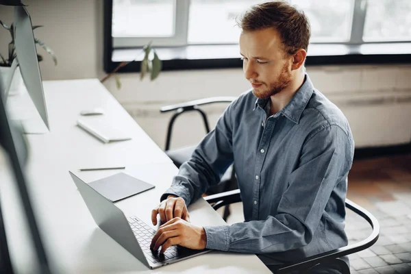Ung affärsman som arbetar med dator på kontoret — Stockfoto