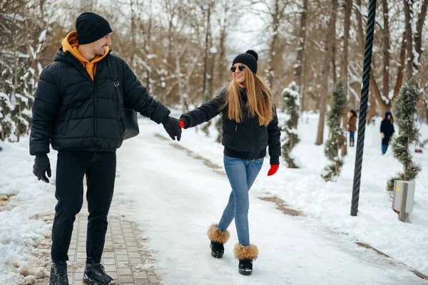 Молода щаслива закохана пара гуляє в зимовому парку — стокове фото