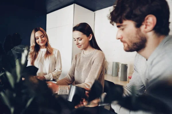 Jovens colegas de negócios fazendo uma pausa para o café no escritório, bebendo e conversando — Fotografia de Stock