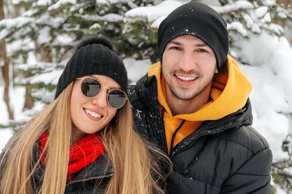 Happy couple hugging and smiling outdoors in snowy park — Stock Photo, Image