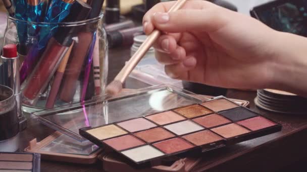 Primer plano de la paleta de maquillaje y sombras de ojos en la mesa de tocador — Vídeo de stock