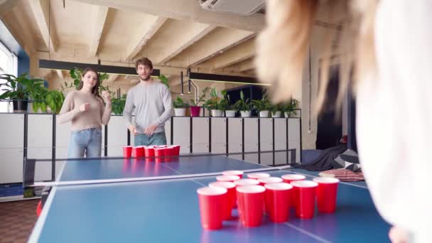 Grupo de jóvenes jugando al pong de cerveza en una gran sala — Vídeos de Stock