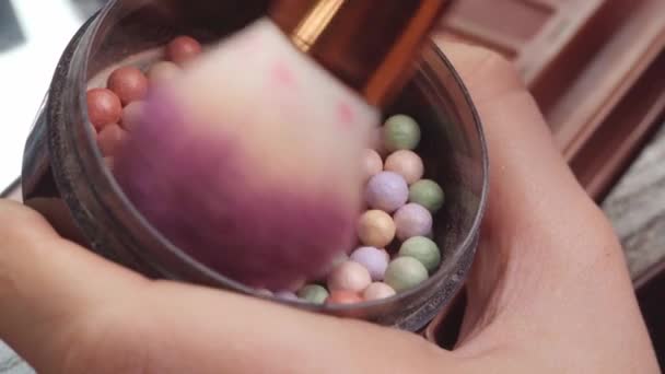 Макіяж пензлем нанесення косметичних кульок порошку на марнославний стіл крупним планом — стокове відео