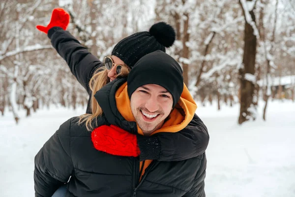 Happy couple hugging and smiling outdoors in snowy park — Stock Photo, Image