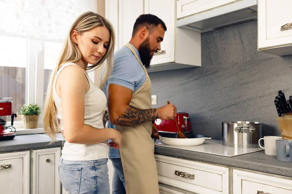 Giovane uomo e donna cucinare il cibo in cucina insieme, coppia felice preparare il cibo — Foto Stock